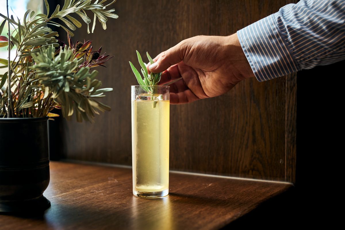 A man garnishes a whisky highball