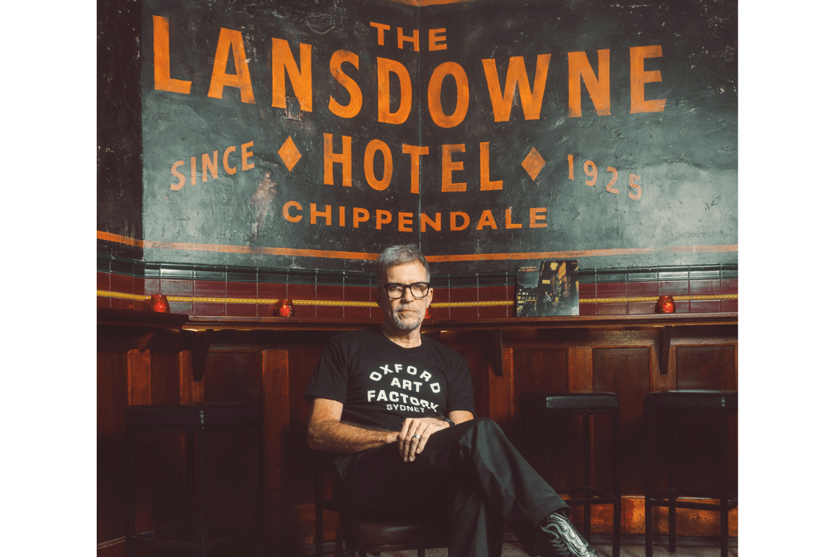 Mark Gerber sitting in front of a black and orange sign that readers 'the Lansdowne Hotel'