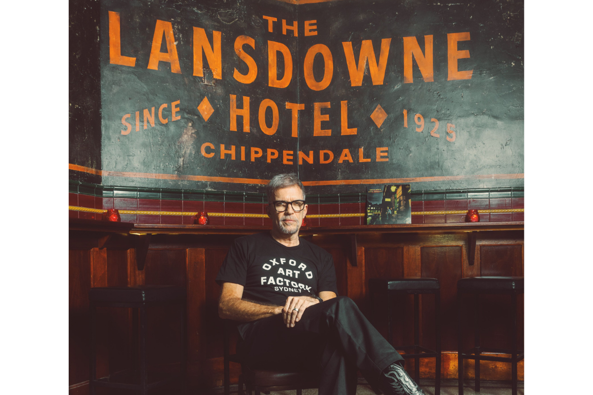 Mark Gerber sitting in front of a black and orange sign that readers 'the Lansdowne Hotel'