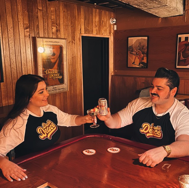Claudia 'Beryl' Morgan and Sebastian 'Cosmo' Soto raising a cocktail in Double Deuce